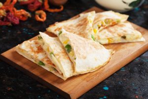 Mexican quesadillas, cheese filled tortilla wraps with salsa and guacamole
